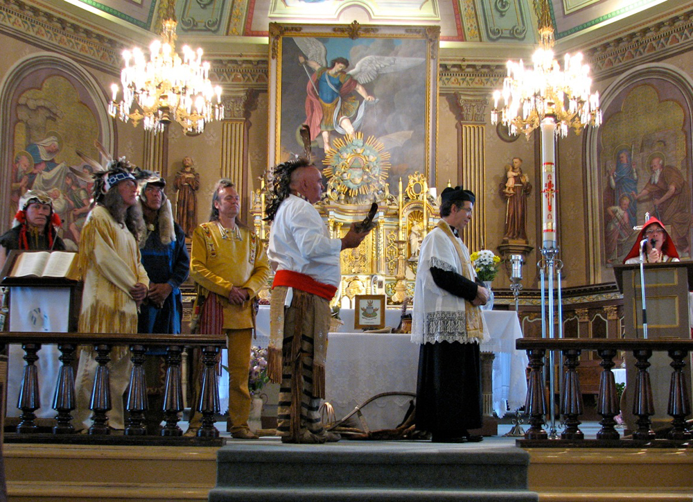 Photographie couleur, intérieur d’une église richement décorée, célébration religieuse dont les participants sont en costumes d’époque. 