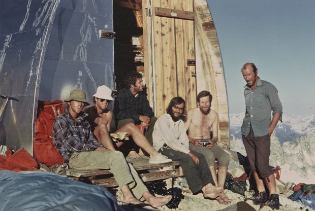 Portrait des membres du groupe assis à l’entrée avant du refuge Plummer en plein soleil estival.