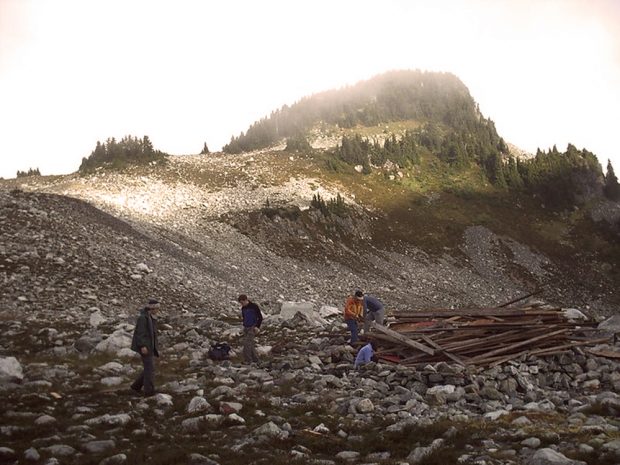 Un groupe de membres de l’UBC-VOC arpentant le pré alpin à la recherche de débris après la destruction du refuge Brew 2.