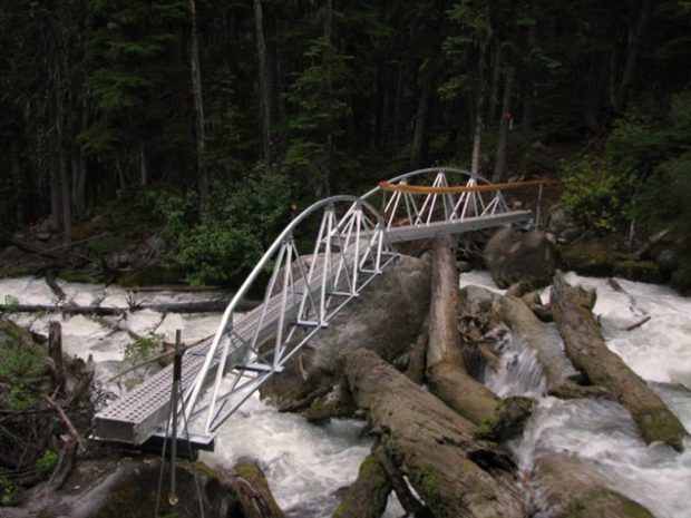 Une nouvelle passerelle dotée de mains courantes métalliques neuves surplombe le ruisseau s’écoulant sur le sentier menant au refuge Harrison.