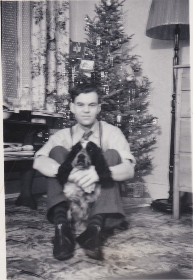 Erik Wadelius est assis par terre devant un sapin de Noël.