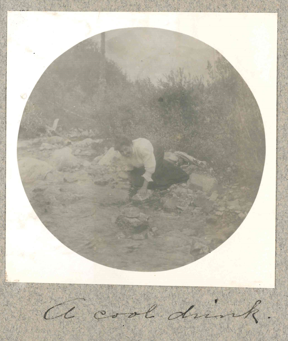 Photo d’une femme au bord d’un ruisseau prenant de l’eau