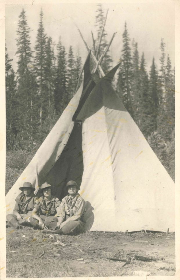 Photo de Dorothy Lougheed entre deux autres filles habillées en éclaireuses, devant un tipi