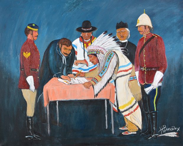 Six personnes assises autour d’une table pendant qu’un chef autochtone en tenue de cérémonie signe un document.