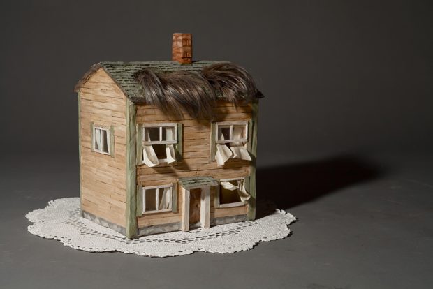 Sculpture d’une maison avec une frange de cheveux