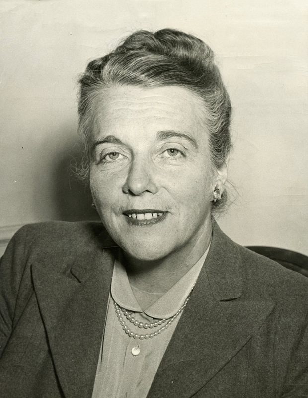 Portrait en noir et blanc d’une femme souriante.