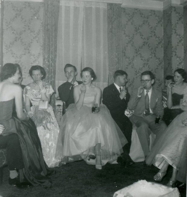 Jeunes personnes élégants lors d'une fête dans une photo en noir et blanc; assise.