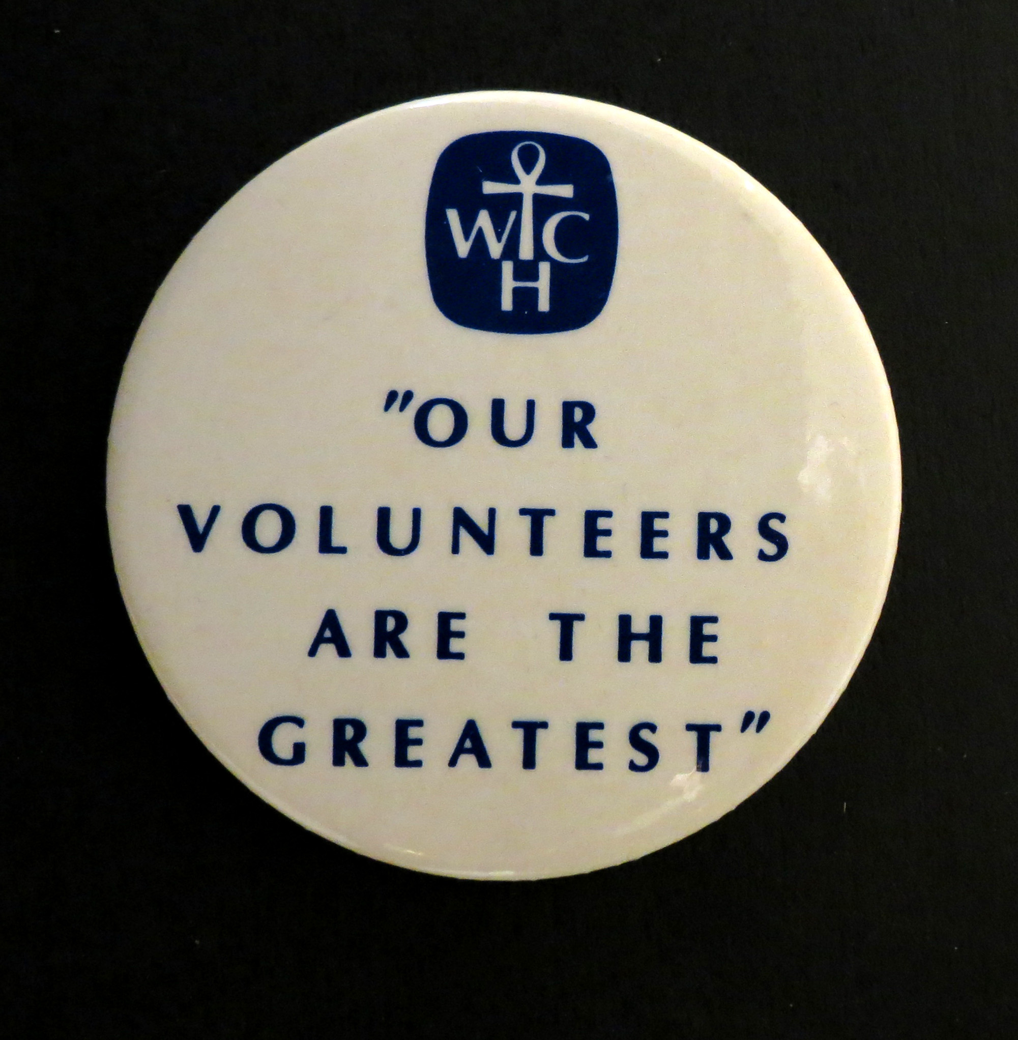 Épingle blanche et logo du Women's College Hospital avec texte en noir disant : Our Volunteers are the Greatest (Nos bénévoles sont les meilleures.)