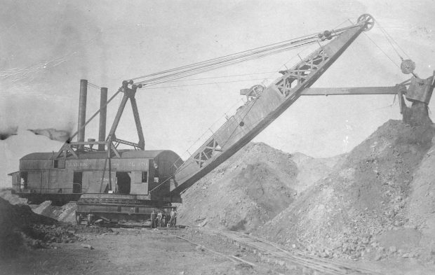 Une pelle à vapeur fait du terrassement pendant la construction du chemin de fer de l’Est