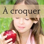 Une fillette regarde une pomme qu'elle a croquée