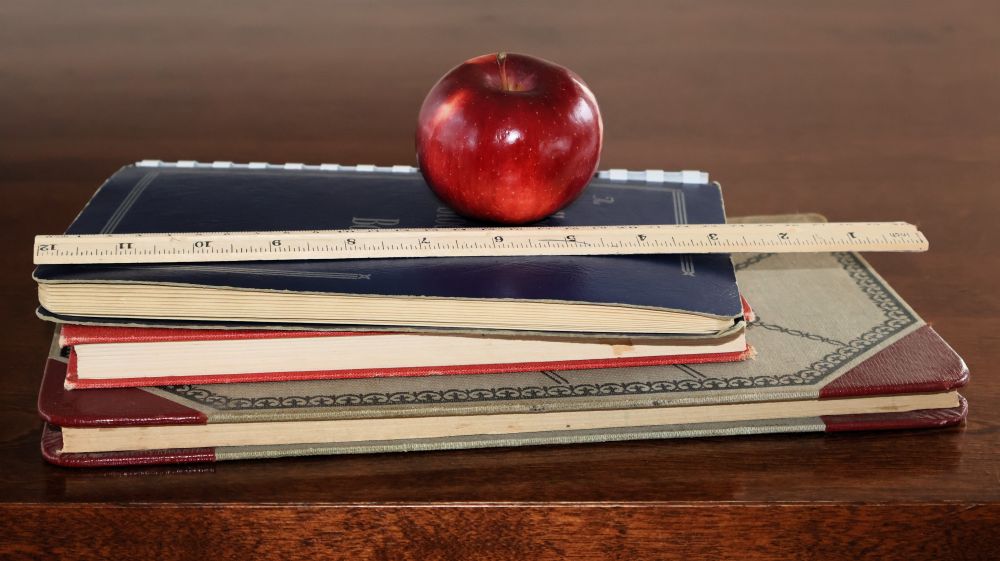 Une pile de livres et une pomme sur le dessus