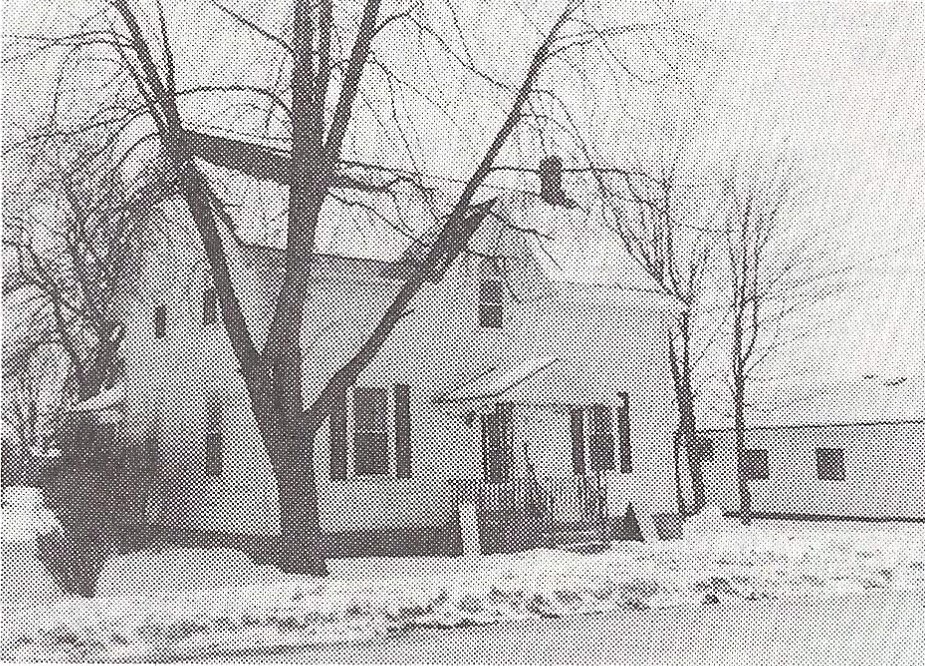 Photographie en noir et blanc d'une petite maison blanche de deux étages en hiver au 235, rue Ottawa, à Almonte.