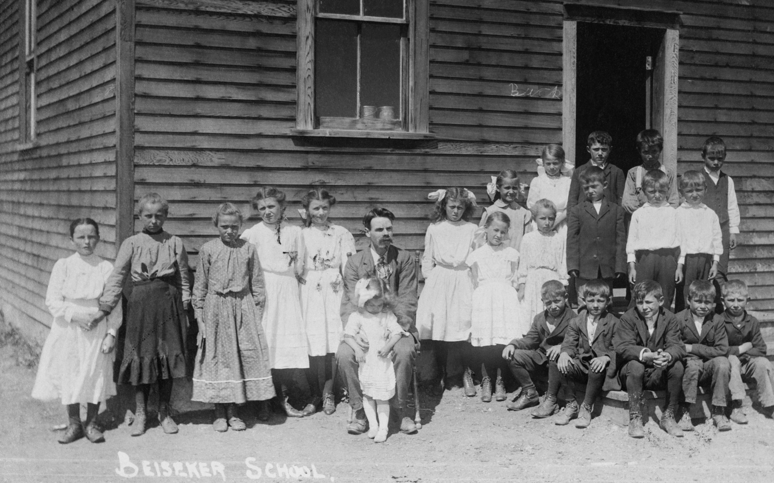 Photo d’élèves se tenant près d’une école en planches à gorge, à Beiseker.