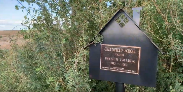 Repère dissimulé dans des arbustes indiquant l’emplacement de l’école de Greenfield,  1913-1950
