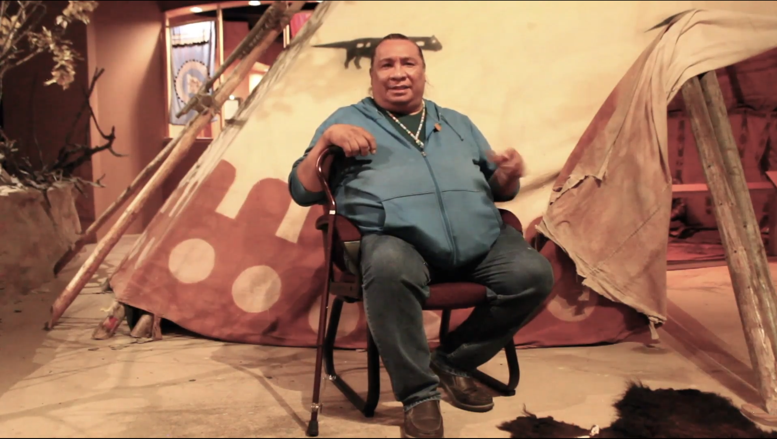 Adrian Wolfleg devant un grand tipi au musée Glenbow.