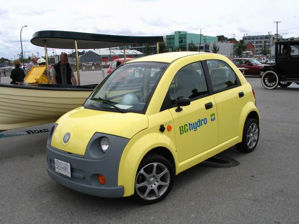 Photo couleur d’une petite voiture électrique aux formes arrondies dans un parc de stationnement. Texte sur la portière : BC HYDRO