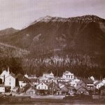 Fernie, C.-B., en 1899, avec le mont Fernie en arrière-plan et une locomotive du Chemin de fer Canadien Pacifique au premier plan.
