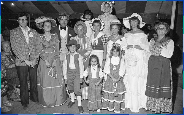 Photographie noir et blanc d’un groupe d’adultes et d’enfants habillés en costume historique.