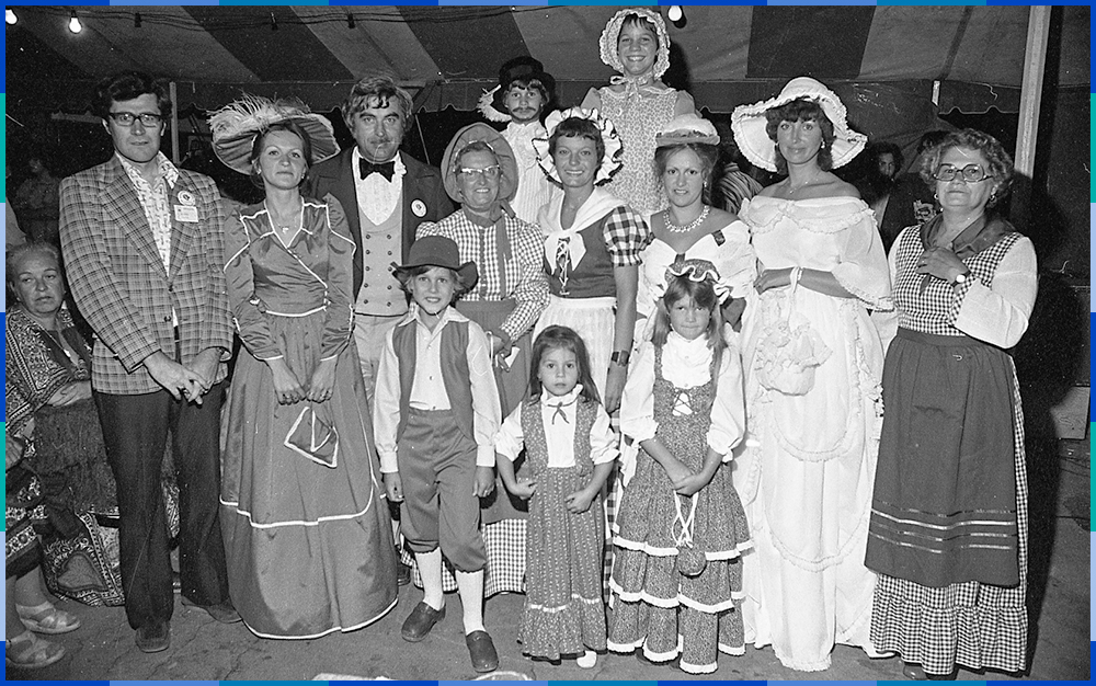 Photographie noir et blanc d’un groupe d’adultes et d’enfants habillés en costume historique.