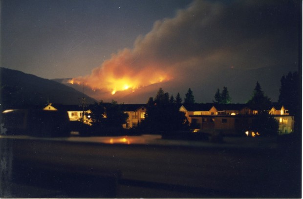 Incendie faisant rage la nuit. Bâtiments éclairés au premier plan.