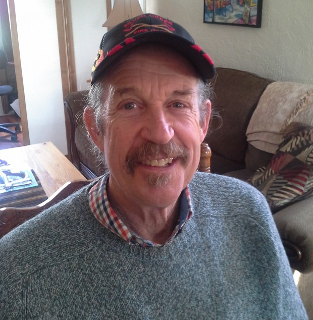 Portrait d'un homme souriant coiffé d'une casquette de baseball.