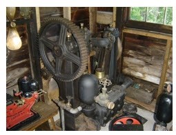 Une grande pompe noire en fer avec un volant. On peut voir les canalisations d’eau qui arrivent et qui partent ainsi que la valve de la canalisation pour couper l’eau. Il s’agit de la pompe utilisée pour fournir de l’eau aux résidents du village tout au long de l’été. Actuellement on peut la voir dans la Collection Forman Hawboldt dans un bâtiment adjacent à l’ancienne gare de Chester (Chester Train Station).