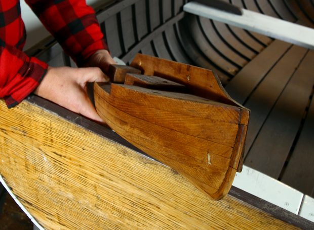 Photographie couleur d’une demi-coque en bois, vue de face.