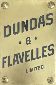 Plaque en laiton avec les mots Dundas & Flavelles Limited, inscrits en encre noire.