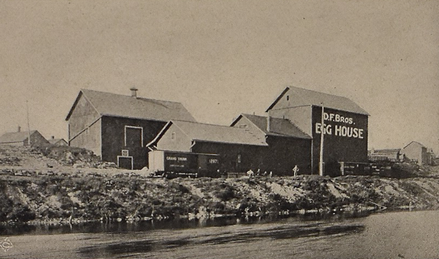 Bâtiments de bois sur le bord d’une rivière.