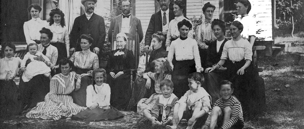 Photo en noir et blanc vers 1902 de la famille Flavelle, composée de 24 personnes, posant devant le chalet de J. R. Dundas..