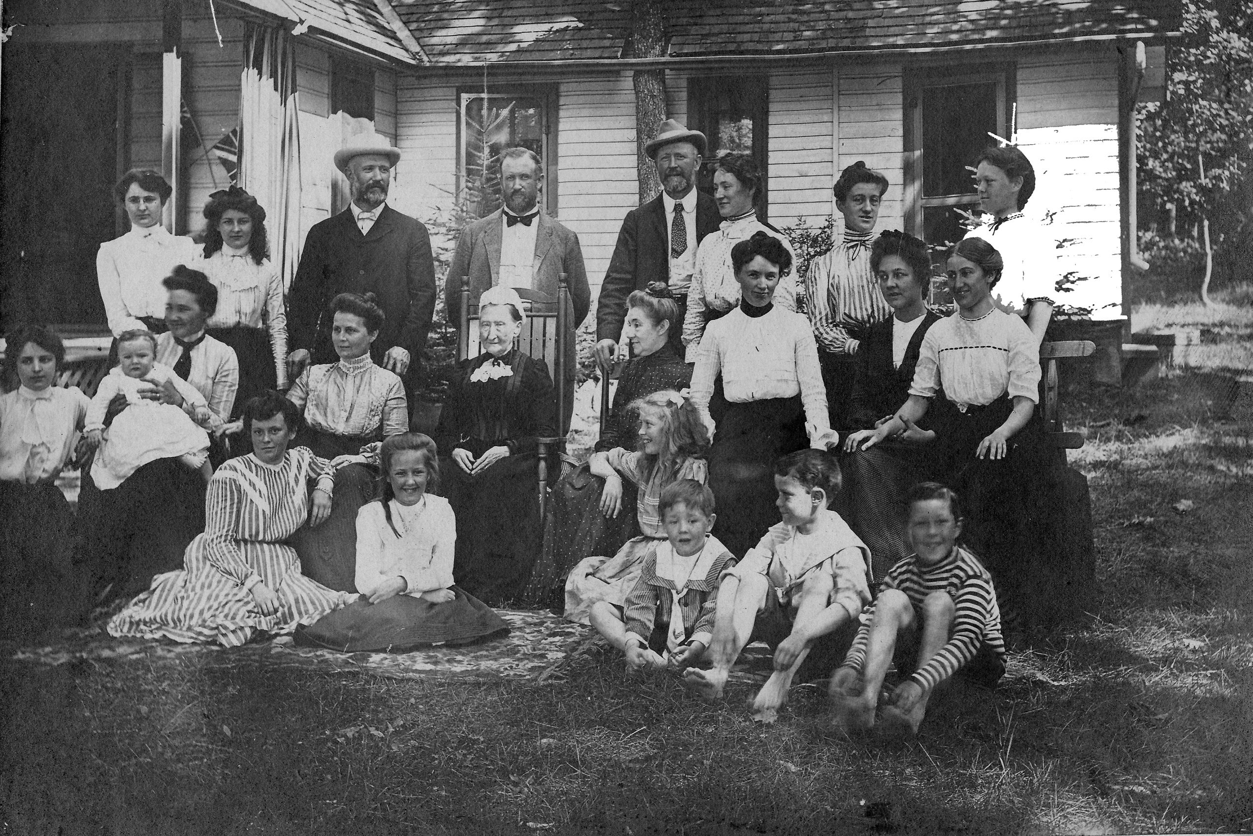 Photo en noir et blanc vers 1902 de la famille Flavelle, composée de 24 personnes, posant devant le chalet de J. R. Dundas..