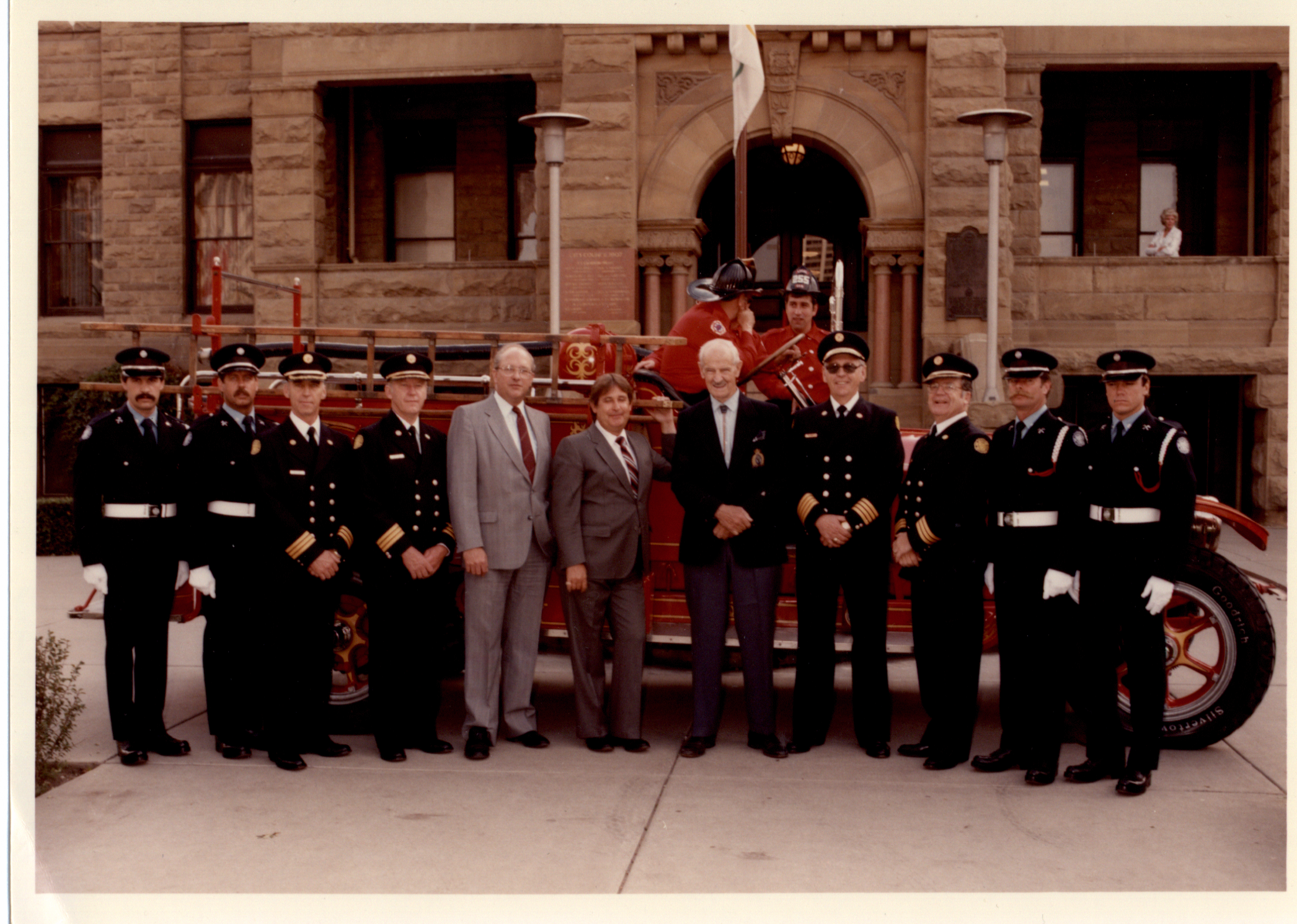 Huit membres de la garde d’honneur avec d’anciens maires, en habit, devant un camion de pompier d’époque et l’hôtel de ville en grès