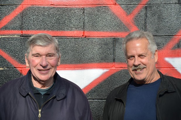 Brian Freney et Dennis McIvor, fondateurs de la garde d’honneur, en tenue décontractée, reçoivent leur plaque commémorative de la part de deux pompiers en uniforme.