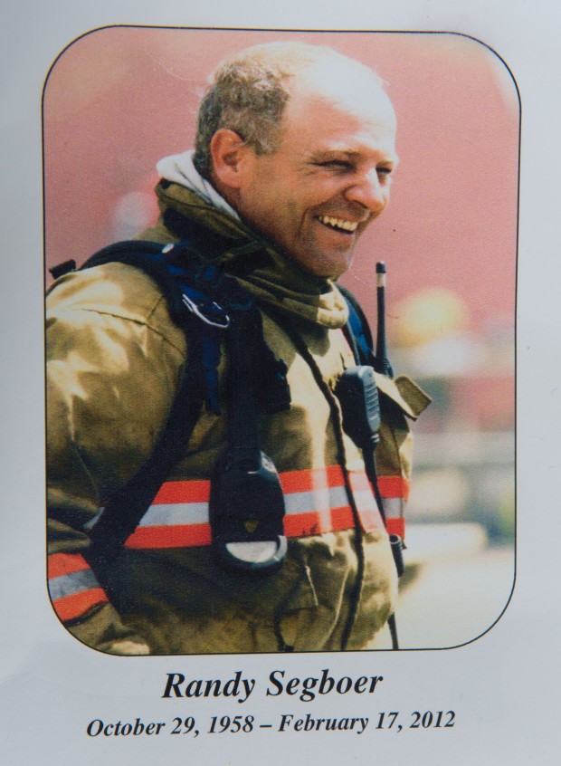 Photo commémorative sur laquelle on aperçoit un pompier souriant en habit de pompier. Inscription sous la photo : « Randy Segboer, 29 octobre 1958 – 17 février 2012 »