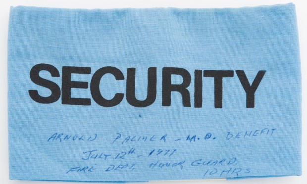 Insigne bleu portant la mention « Security » en caractères d’impression, avec notes manuscrites en encre bleue au sujet de l’événement caritatif Arnold Palmer