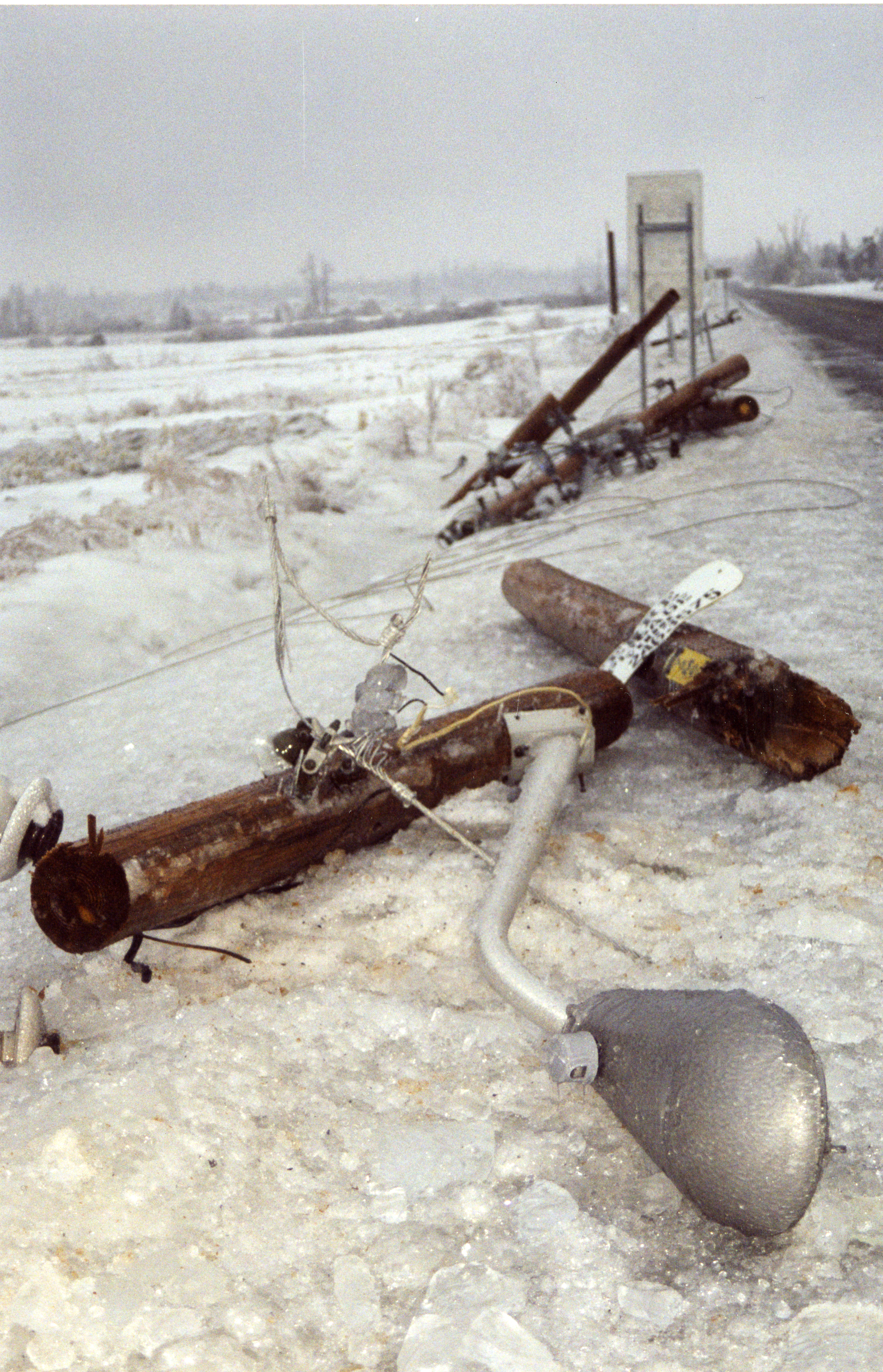 Un lampadaire accroché à un poteau électrique est tombé sous le poids de la glace.