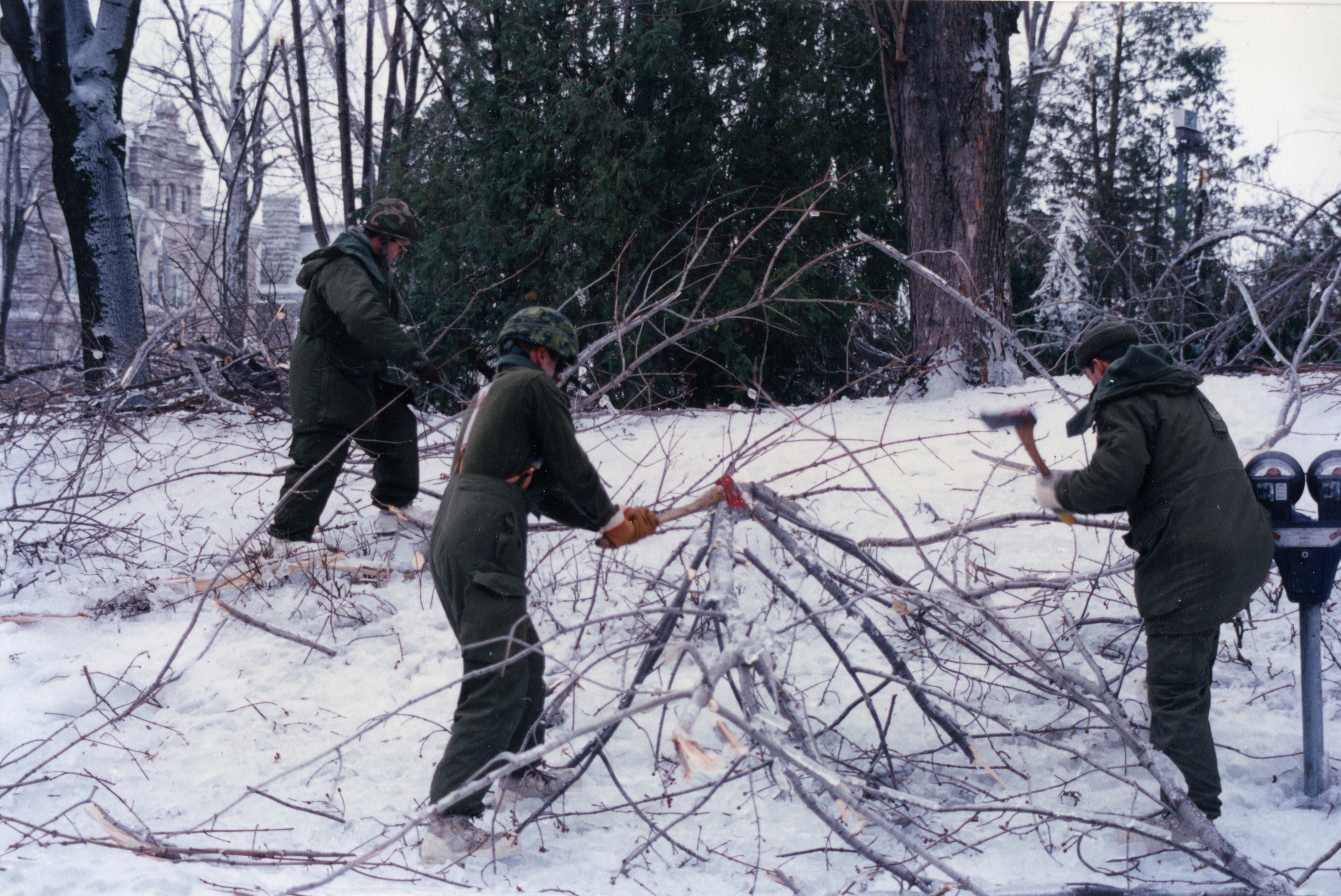 Les militaires brisent les branches à la hache pour les ramasser.