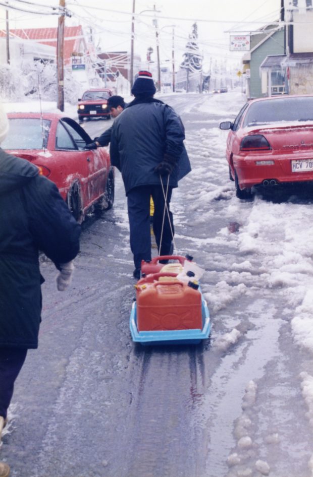 Ce citoyen transporte ses bidons d'essence dans un traîneau, profitant de la surface gelée des rues.