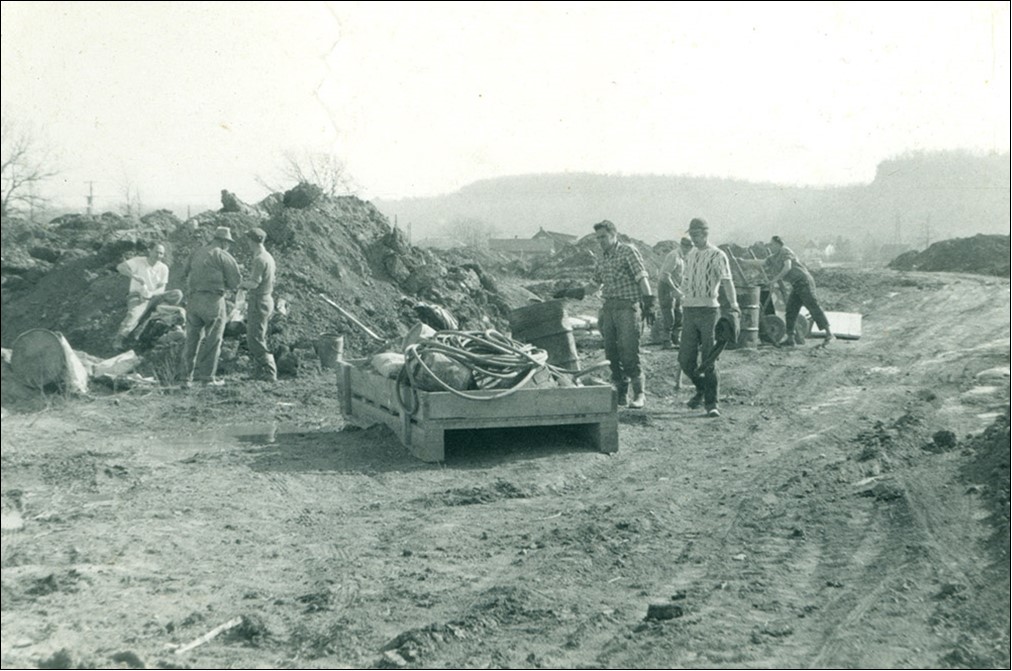 Photo noir et blanc d’hommes en cours de débroussaillage.