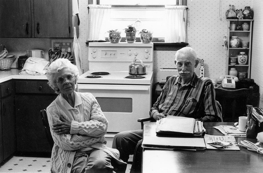 Illustration noir et blanc de deux personnes attablées dans une cuisine.