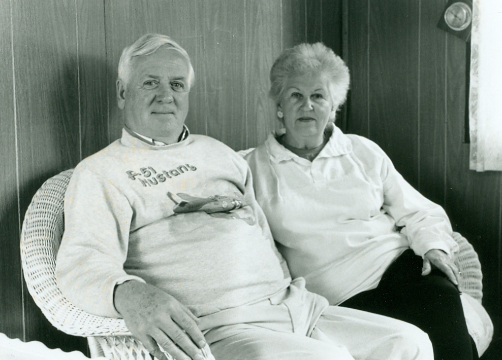 Photo noir et blanc de deux personnes assises sur un sofa en osier.