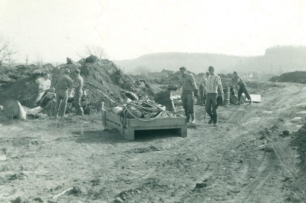 Photo noir et blanc d’hommes en cours de débroussaillage.