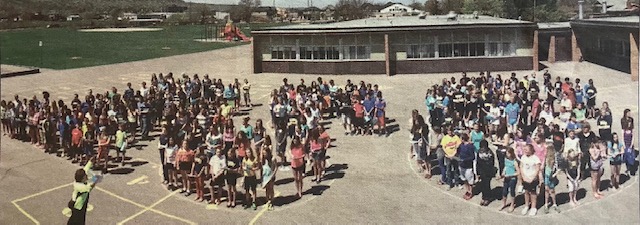 Photo couleur d’élèves à l’école Lakeview ; les enfants sont posés en groupes pour former les lettres LSC.