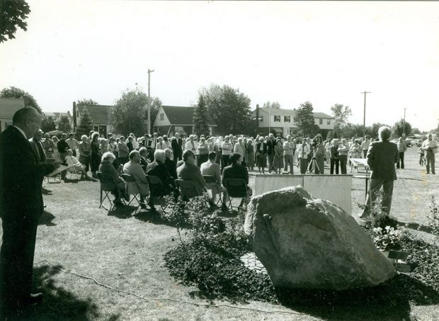 Photo noir et blanc d’un rassemblement de personnes dans un parc.