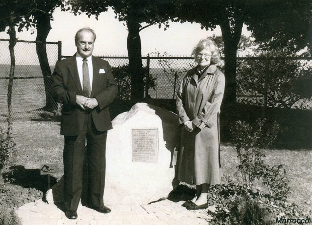 Photo noir et blanc d’un homme et d’une femme près d’une pierre sur laquelle est fixée une plaque.