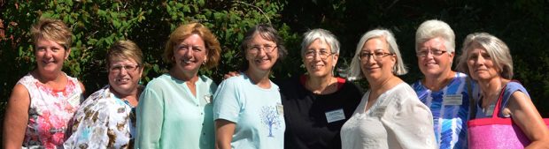 Photo couleur d’un groupe de huit femmes alignées sur un rang.