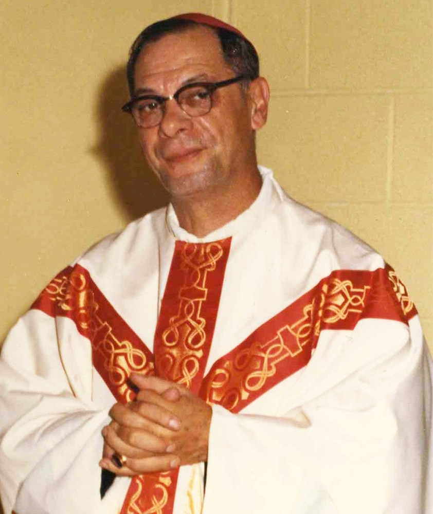 Photo couleur d’un prêtre habillé de blanc et de rouge