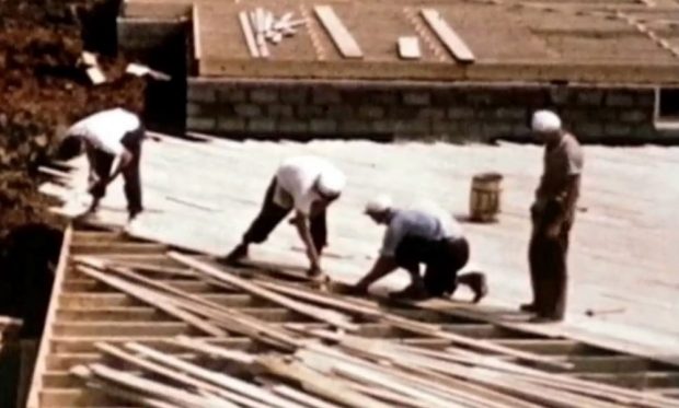 Photo couleur de deux hommes travaillant sur un chantier de construction ; photo prise à une certaine distance.