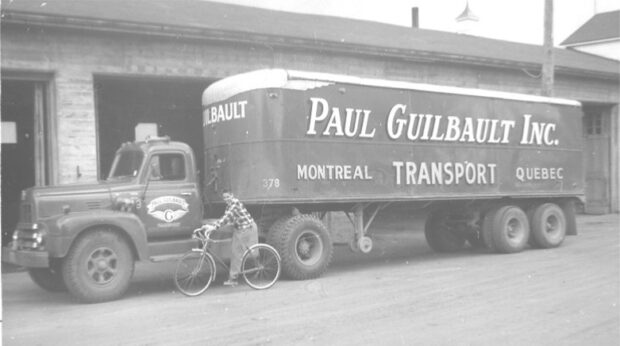 Photo en noir et blanc d'un jeune cycliste à côté d'un camion.
