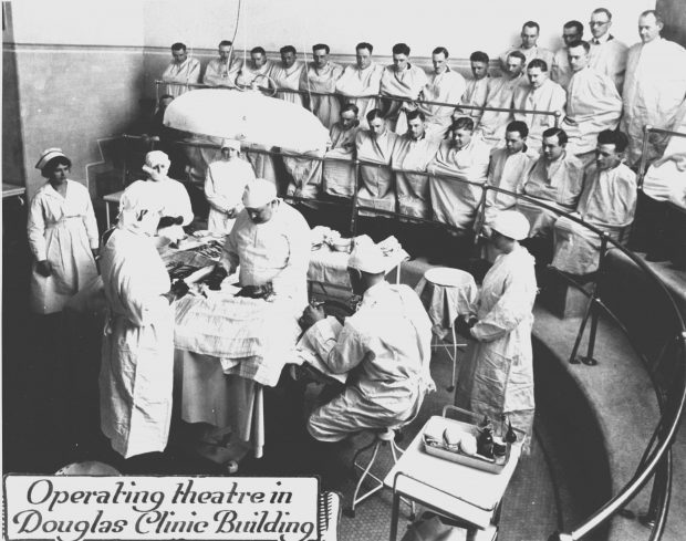 Salle d'opération de la clinique Douglas, 1927 avec docteurs et infirmières. Plusieurs étudiants sont présent dans les estrades